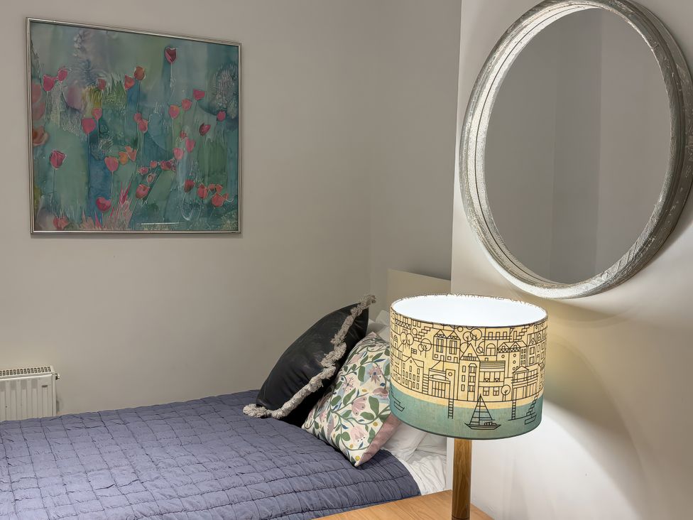 A bedroom with a bed and a mirror at Dart Views in Dartmouth