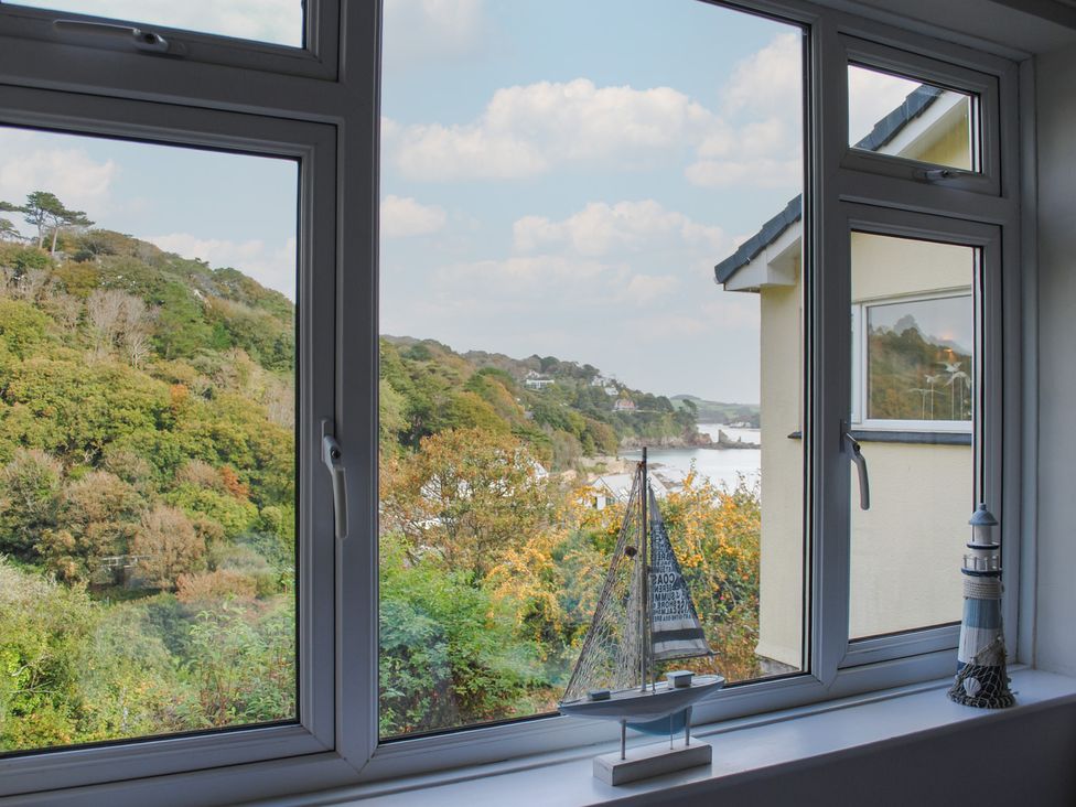 A view from a living room window with decorations and trees at Dolphins in Salcombe