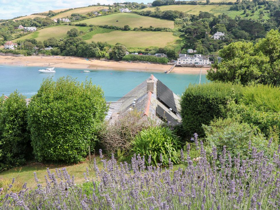 A view of the beach and sea with greenery and lavender at Edinburgh House in Salcombe
