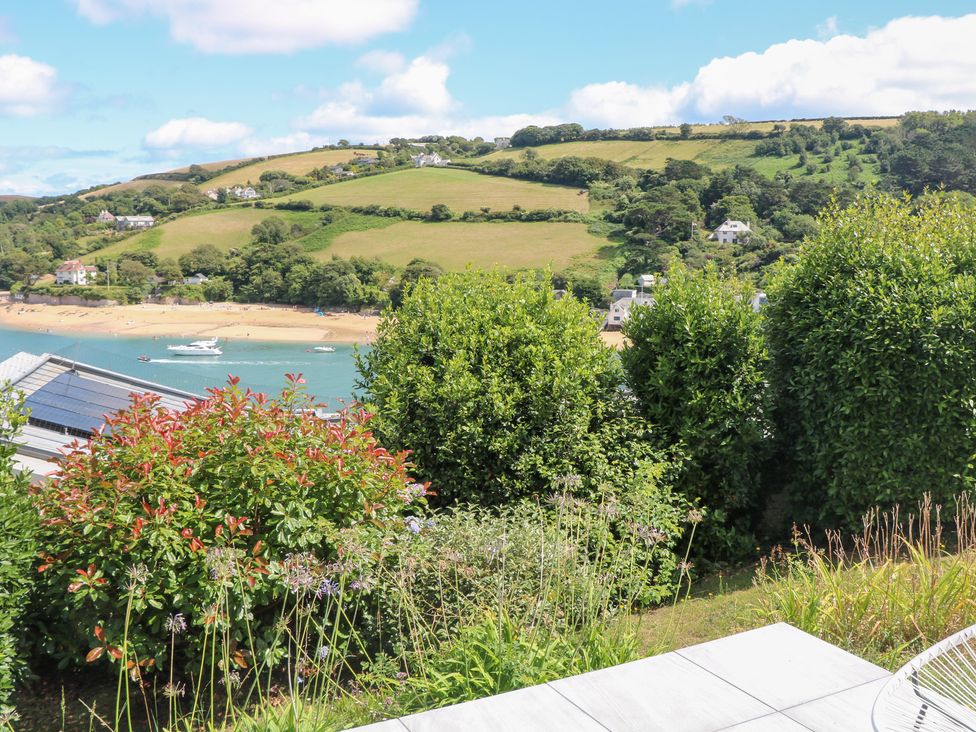 A garden view overlooking a beach and hills at Edinburgh House Salcombe