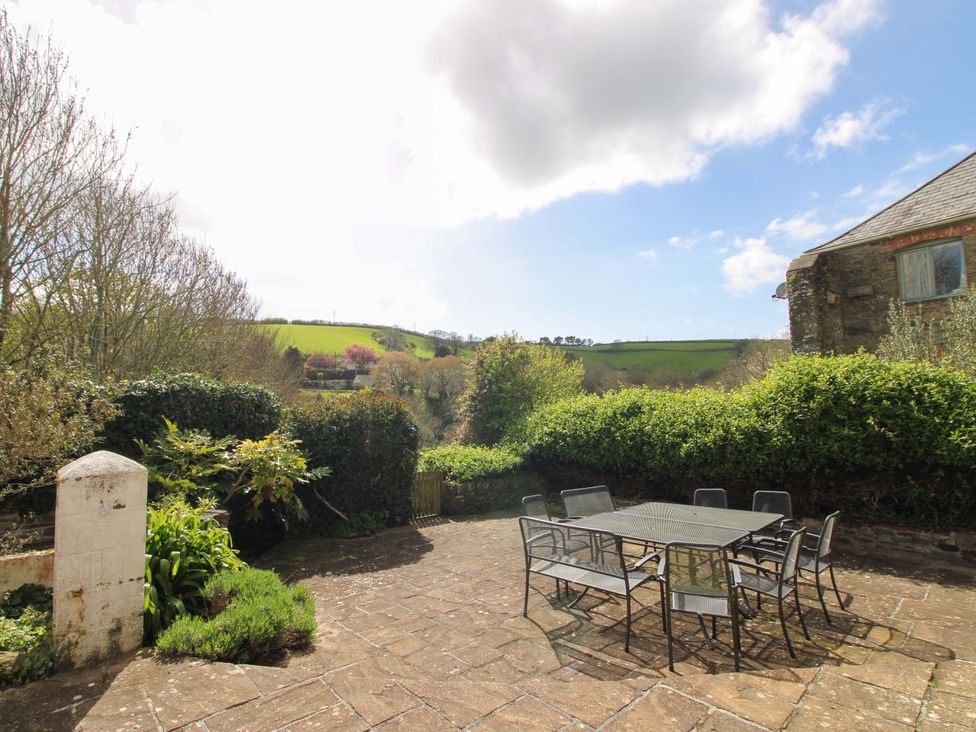 A garden with a table and chairs at Orchard Barn Salcombe