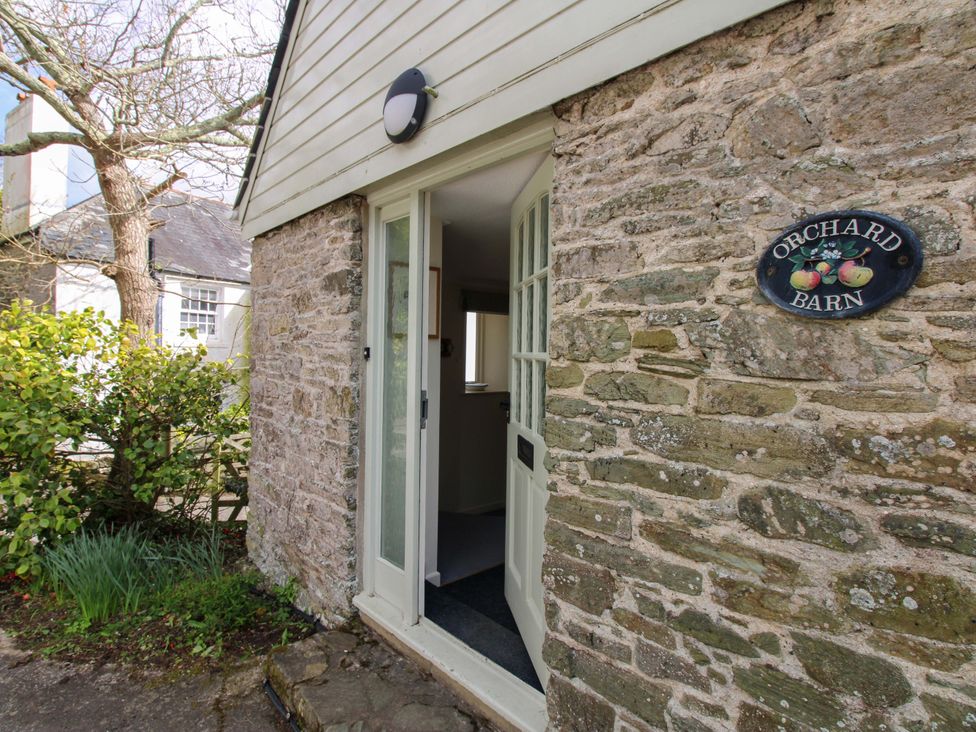An entrance with a stone wall and sign at Orchard Barn in Salcombe