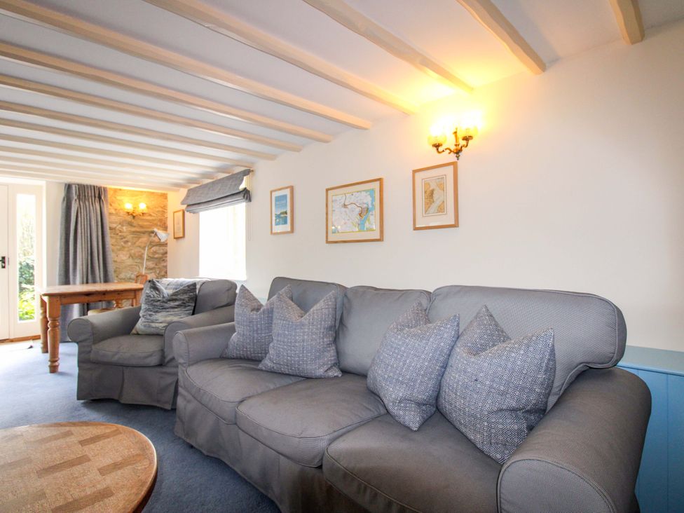 A living room with a sofa and table at Orchard Barn in Salcombe