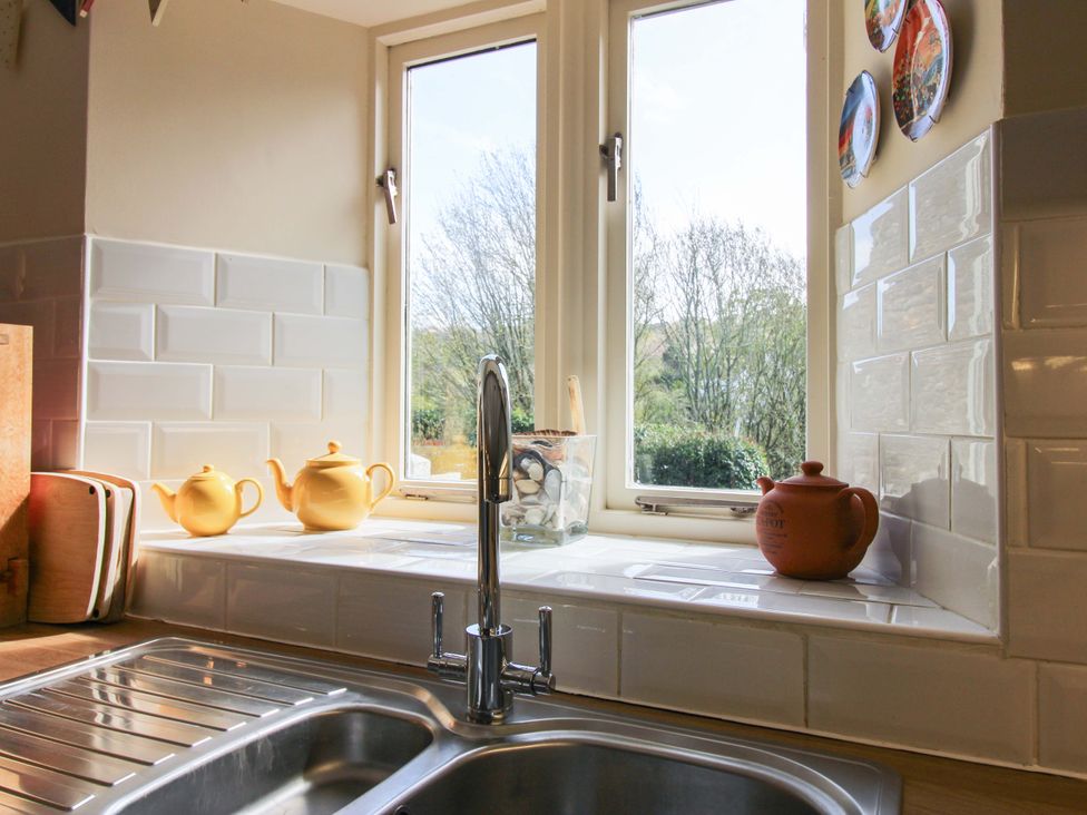 A kitchen with a sink and teapots at Orchard Barn Salcombe