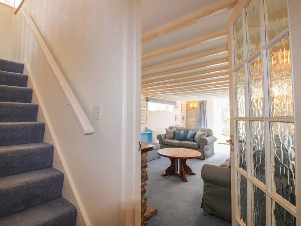A living room with a sofa and table at Orchard Barn in Salcombe