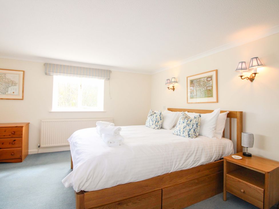 A bedroom with a bed and bedside table at Orchard Barn Salcombe