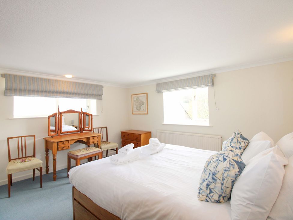 A bedroom with a bed and vanity at Orchard Barn Salcombe