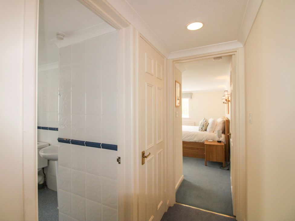A hallway leading to a bathroom and bedroom at Orchard Barn Salcombe