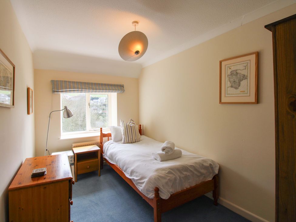 A bedroom with a single bed and lamp at Orchard Barn Salcombe