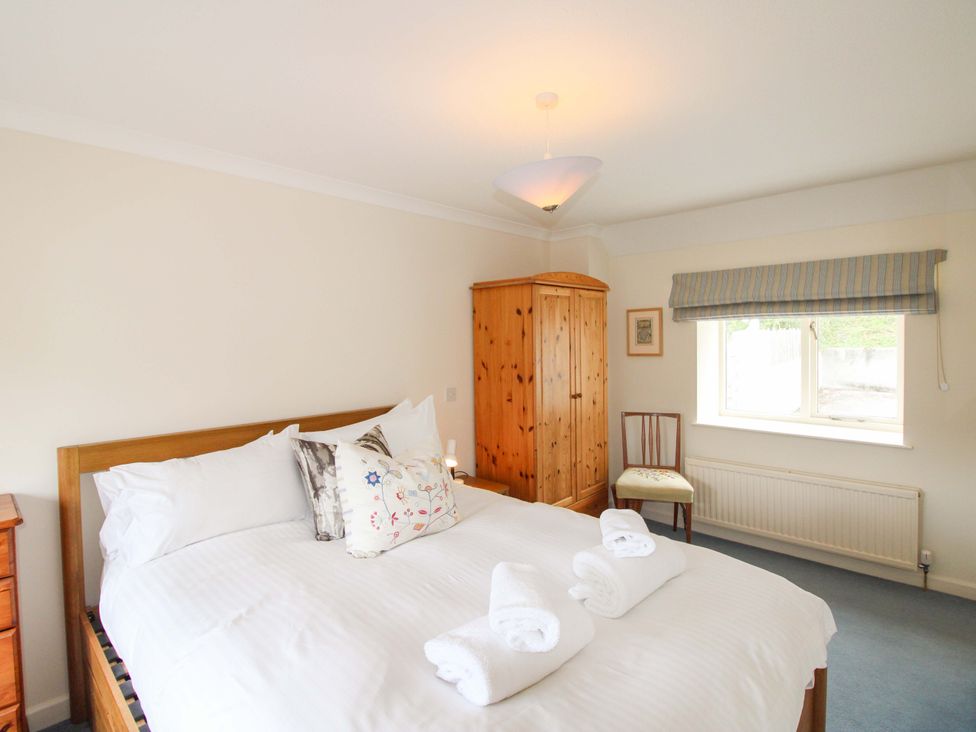 A bedroom with a bed and wardrobe at Orchard Barn Salcombe