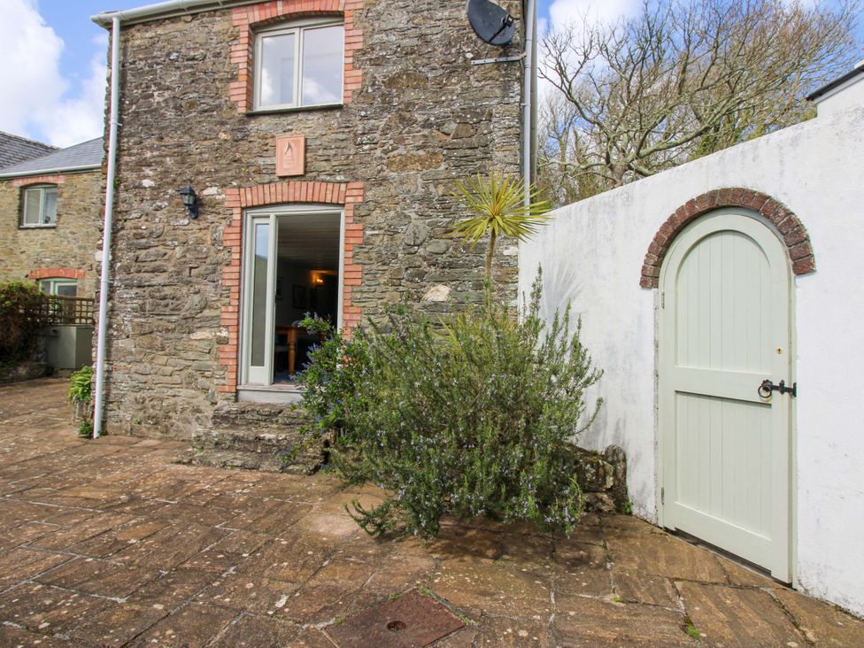 An outdoor area with a stone building and a paved path at Orchard Barn Salcombe