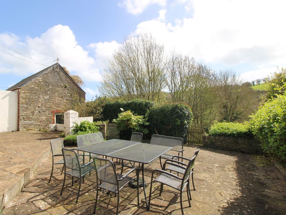 An outdoor patio area with a table and chairs at Orchard Barn Salcombe