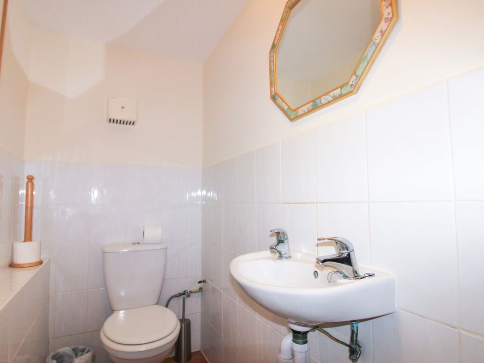 A bathroom with a toilet and sink at Orchard Barn Salcombe