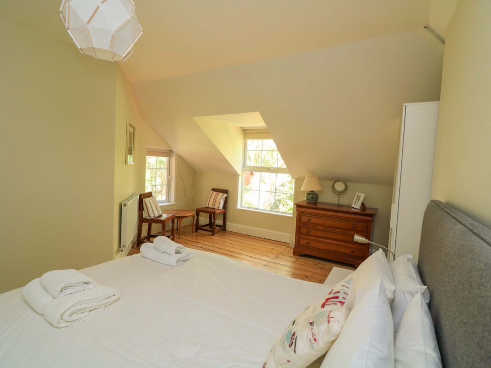 A bedroom with a bed and chairs at Savernake Thurlestone