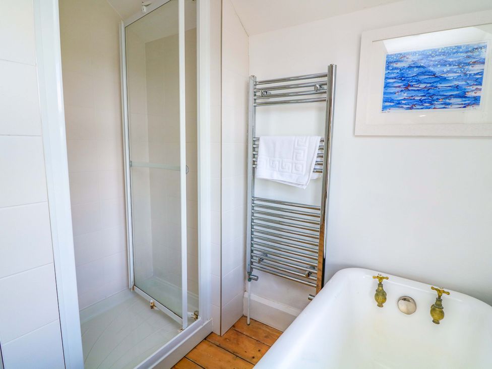A bathroom featuring a shower, bathtub, and towel rail at Savernake in Thurlestone