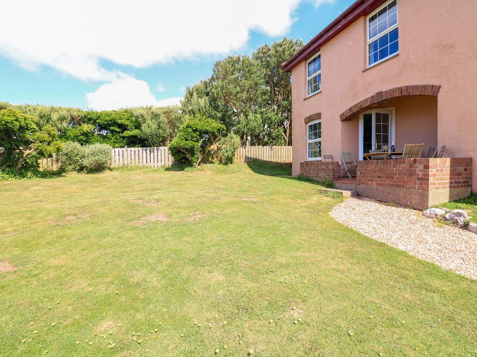 A garden with a house and patio at Savernake Thurlestone