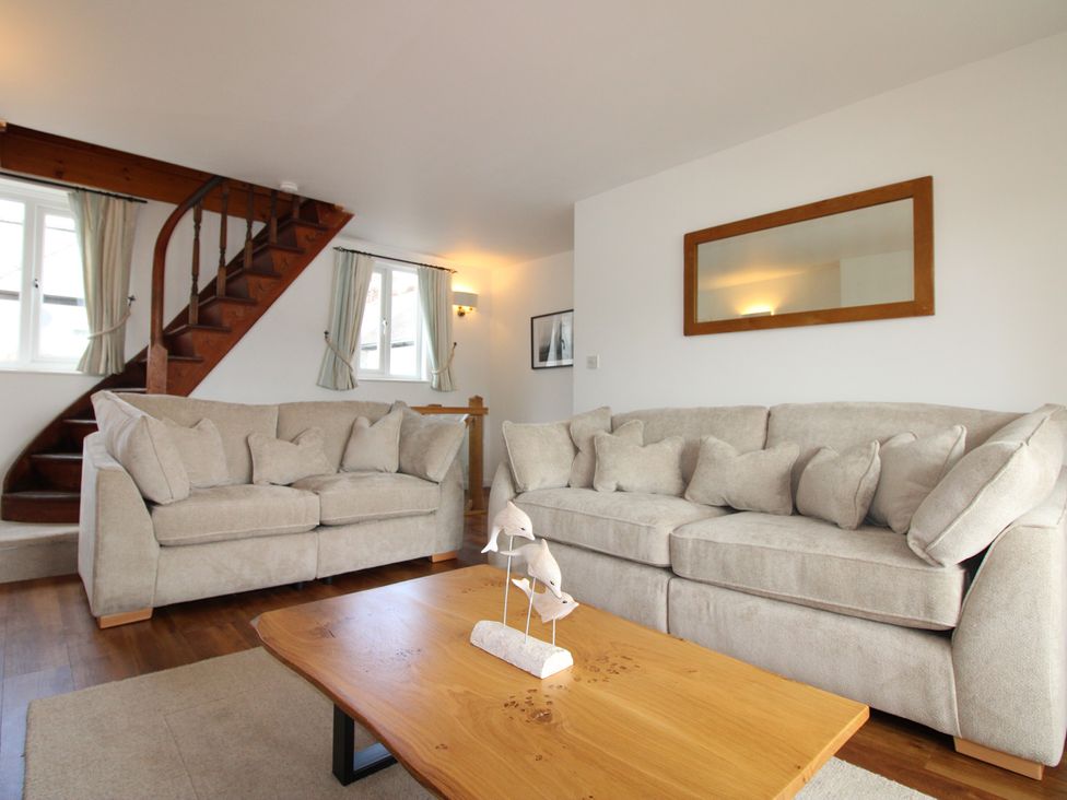 A living room with a staircase and sofas at Seagulls in Salcombe