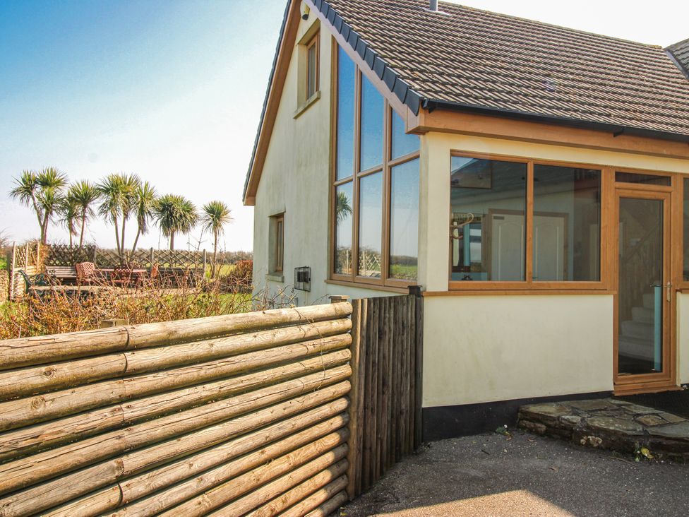 A house with a fence and palm trees at The Station in Bolberry