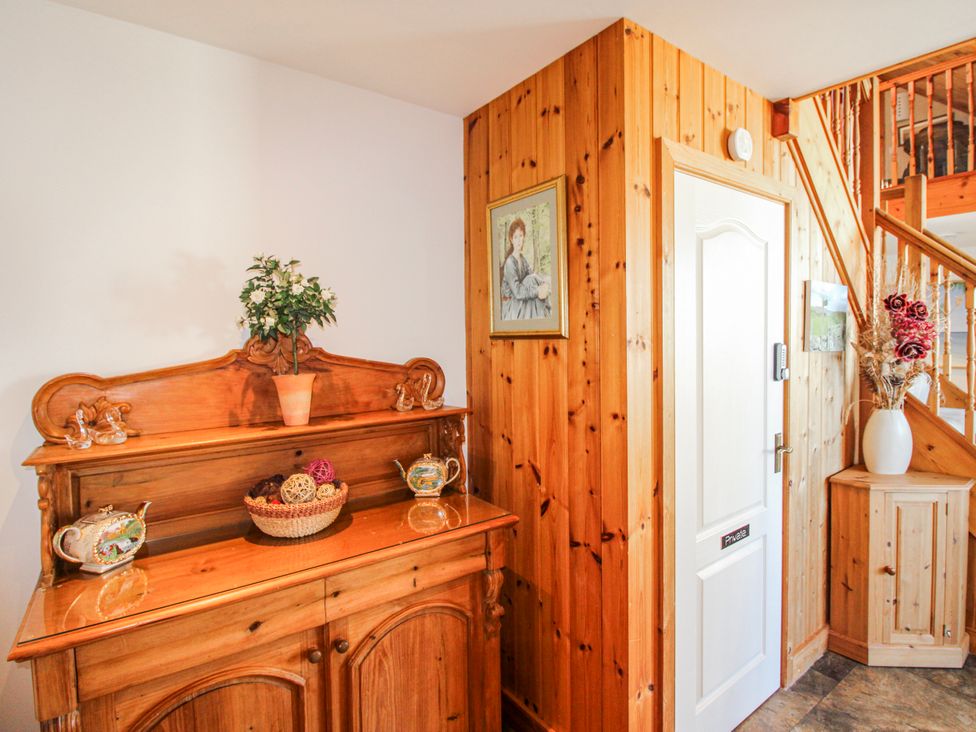 A hallway with a wooden cabinet and decorative items at The Station in Bolberry