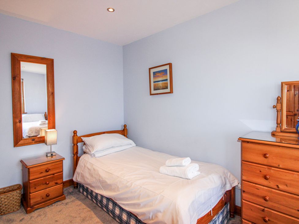 A bedroom with a single bed and wooden furniture at The Station in Bolberry