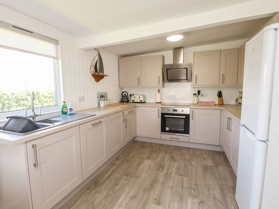A kitchen with modern cabinets and appliances at Maes Y Coed Morfa Nefyn