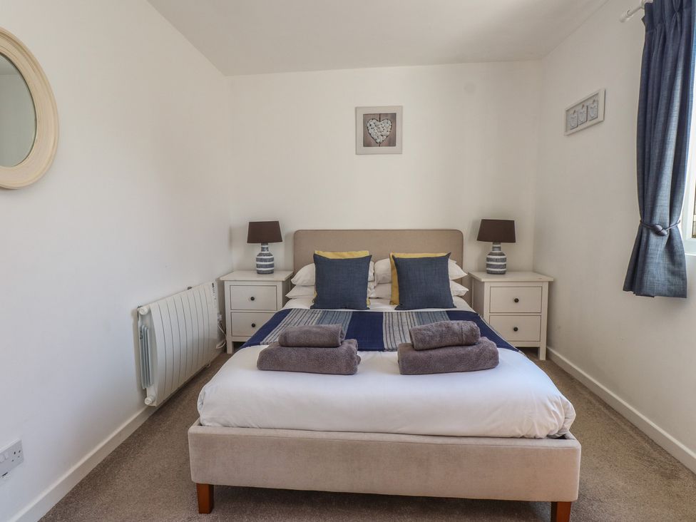 A bedroom with a bed and nightstands at Maes Y Coed in Morfa Nefyn