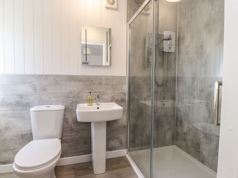 A bathroom with a shower, sink, and toilet at Maes Y Coed in Morfa Nefyn