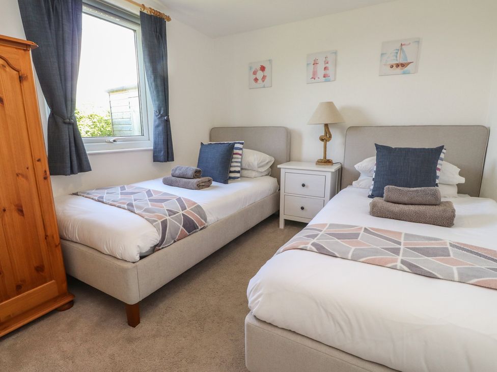 A bedroom with two beds and a nightstand at Maes Y Coed in Morfa Nefyn