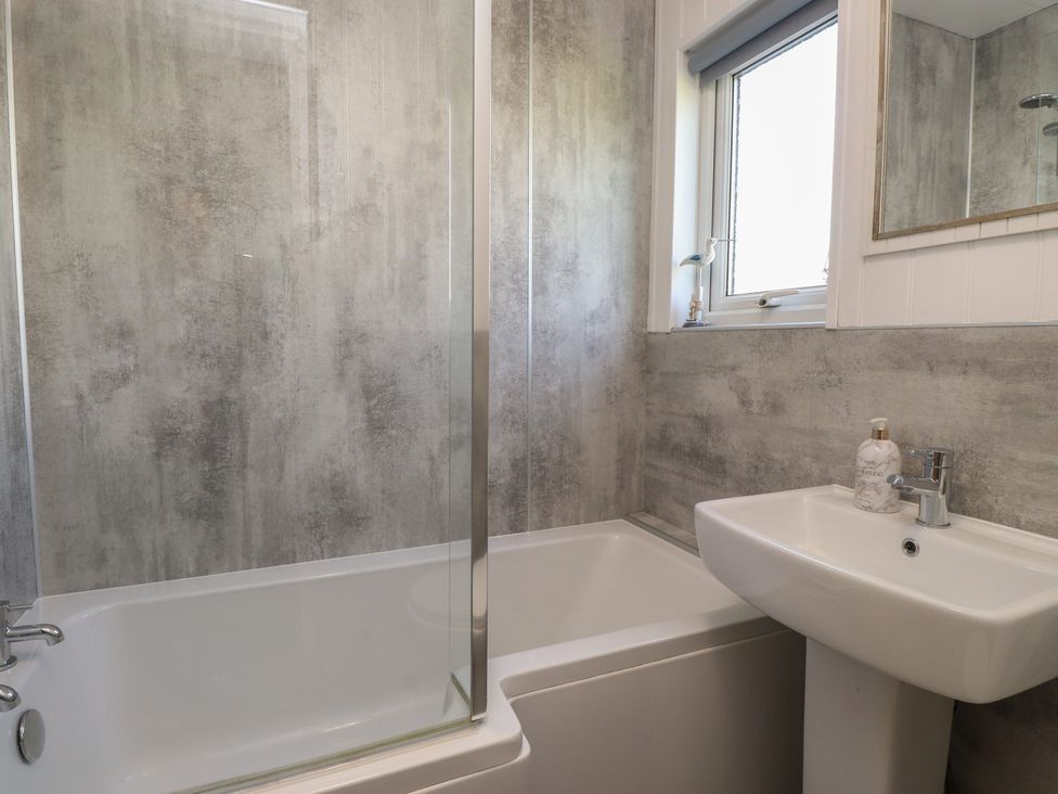 A bathroom with a bathtub and sink at Maes Y Coed in Morfa Nefyn
