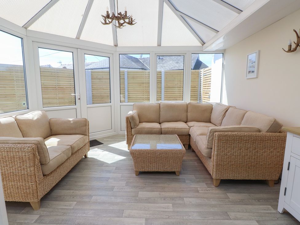 A conservatory with a sofa and coffee table at Maes Y Coed in Morfa Nefyn