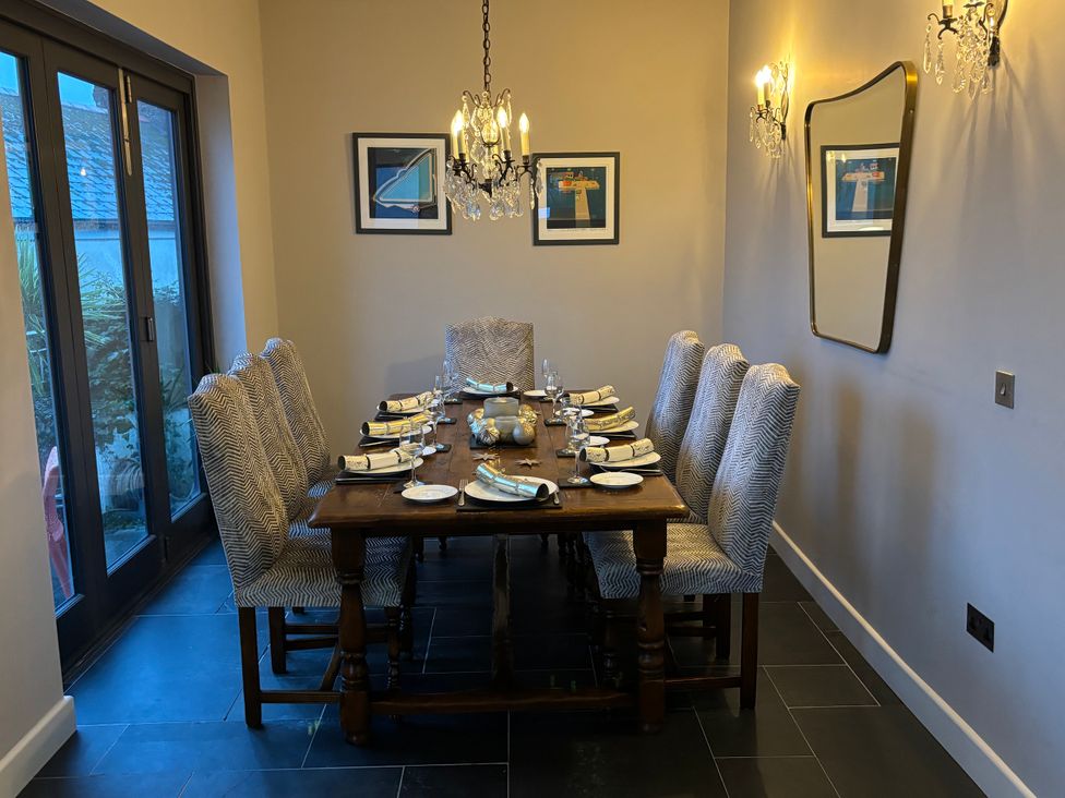 A dining room with a large table and chairs at Postcard Lodge in Polruan