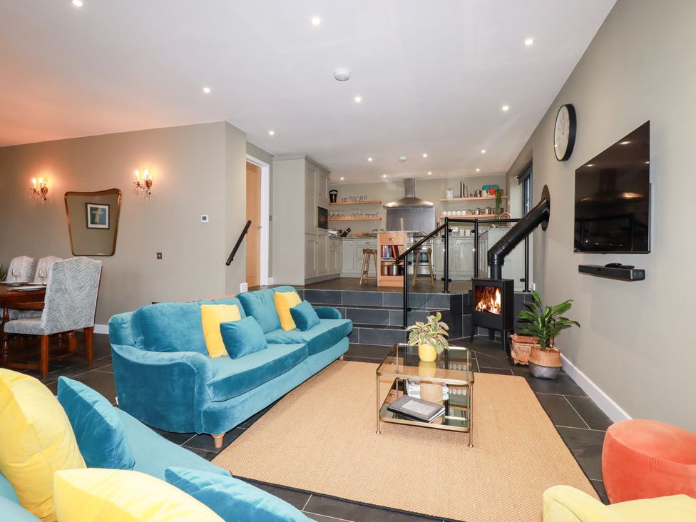 A living room with a sofa and dining area at Postcard Lodge Polruan