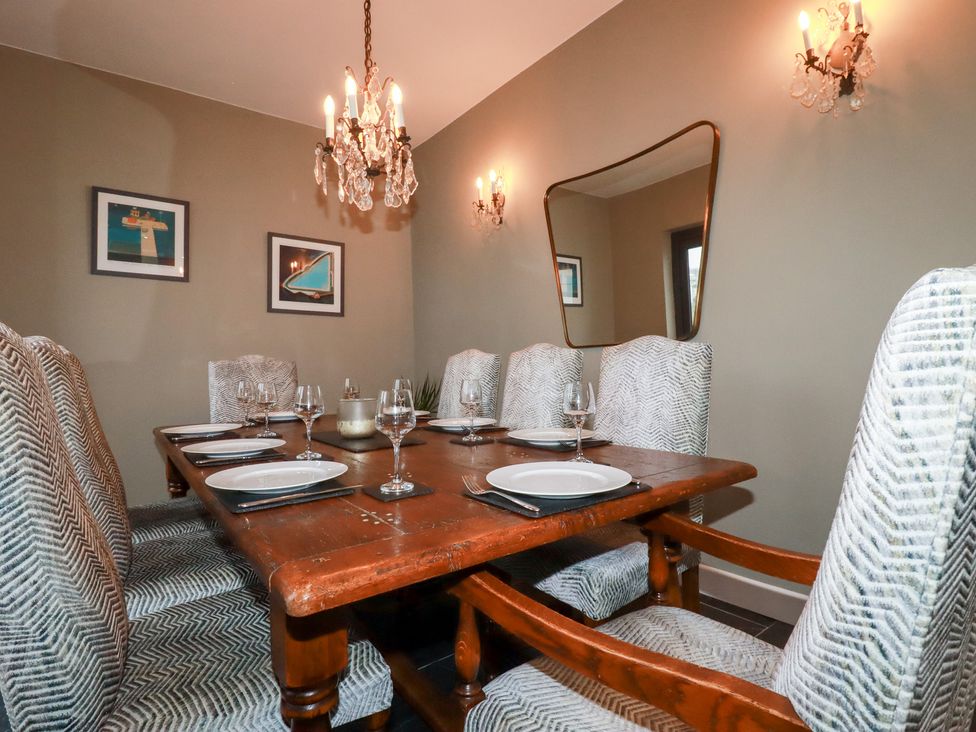 A dining room with a wooden table and chairs at Postcard Lodge in Polruan