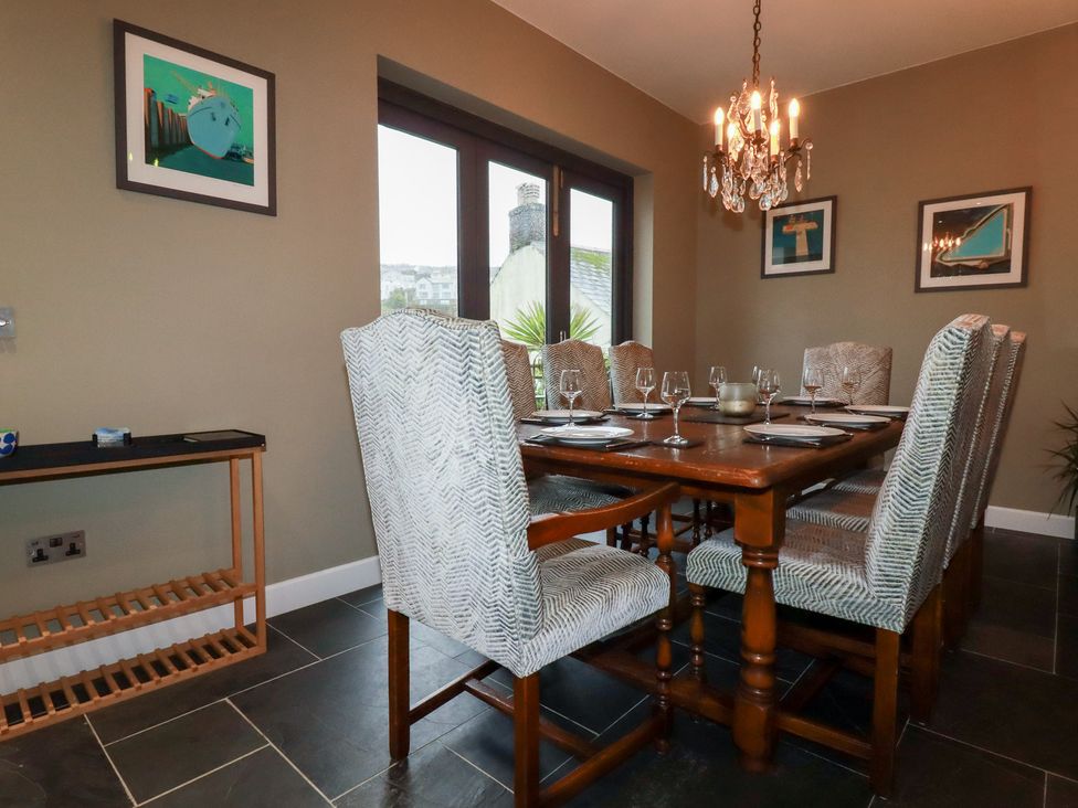 A dining room with a wooden table and chairs at Postcard Lodge Polruan