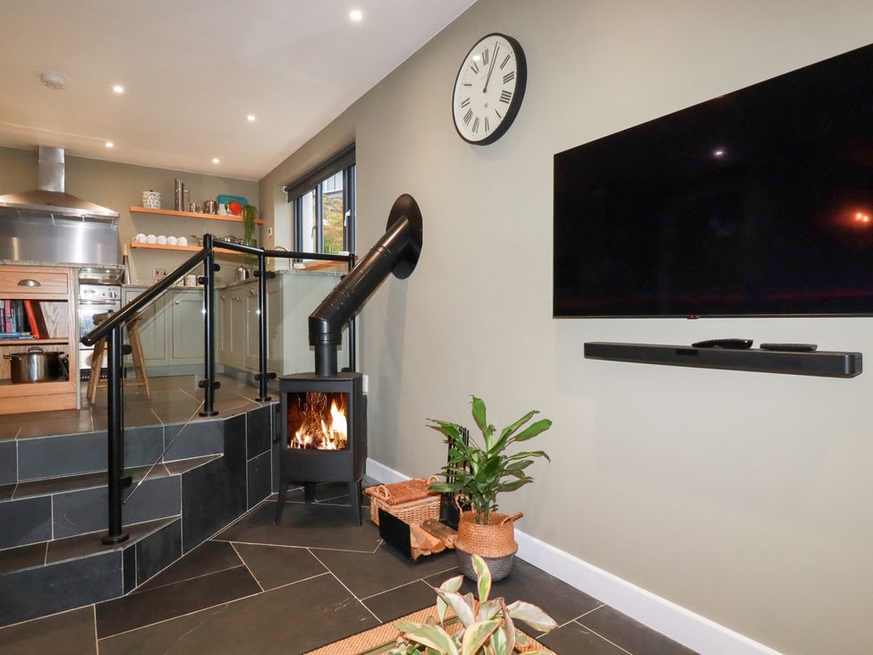 A kitchen with a fireplace and television at Postcard Lodge Polruan