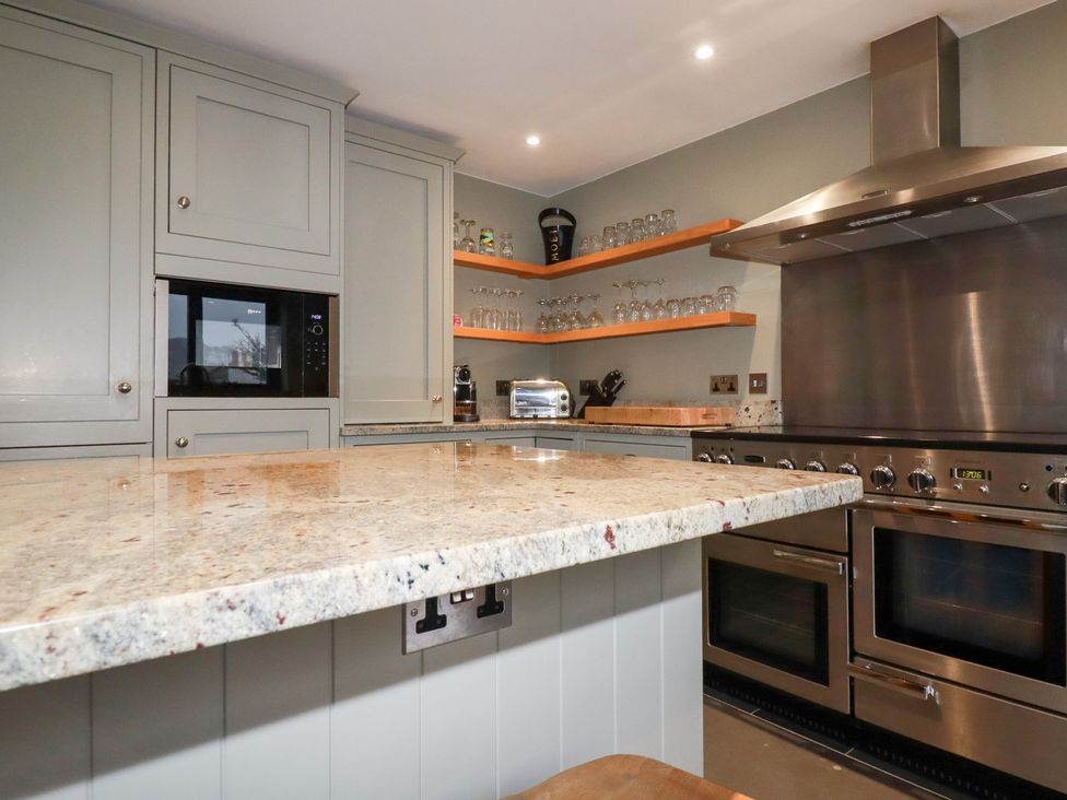 A kitchen with an island and appliances at Postcard Lodge in Polruan