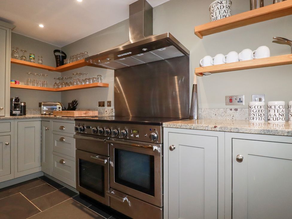 A kitchen with stainless steel appliances and cabinetry at Postcard Lodge Polruan