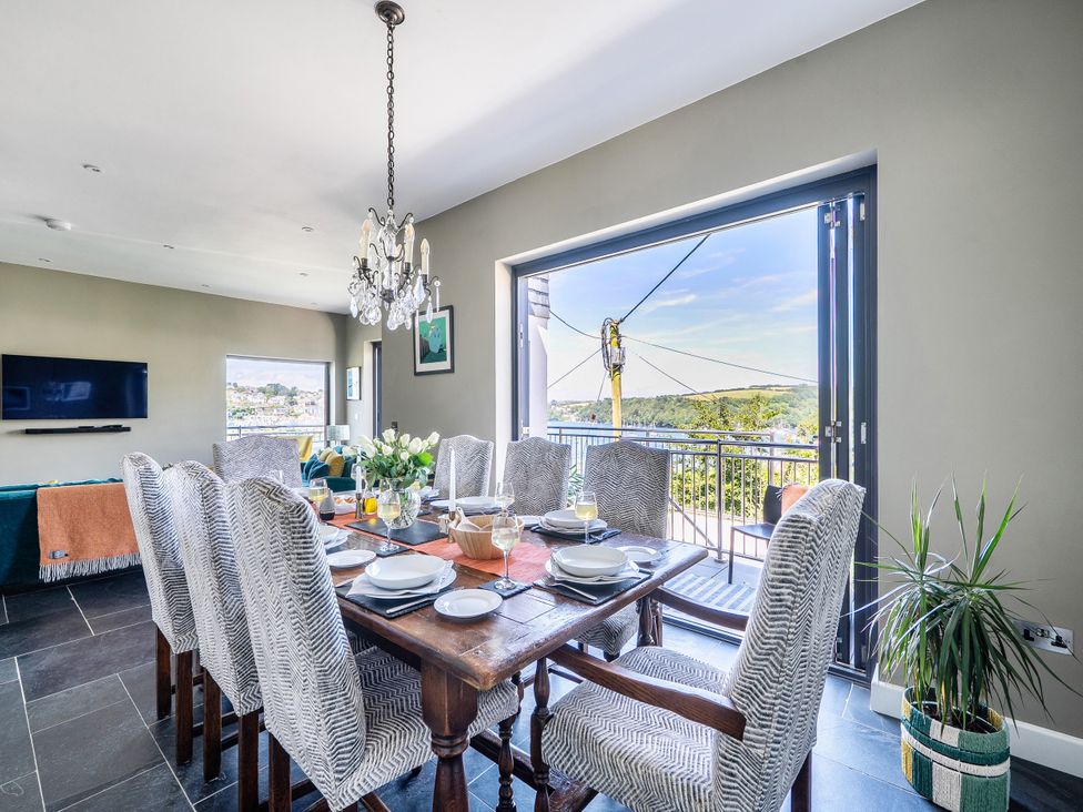 A dining room with a table set for meals at Postcard Lodge in Polruan