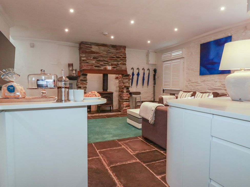 A living room with a sofa and fireplace at Rock House near Trebarwith Strand near Tintagel