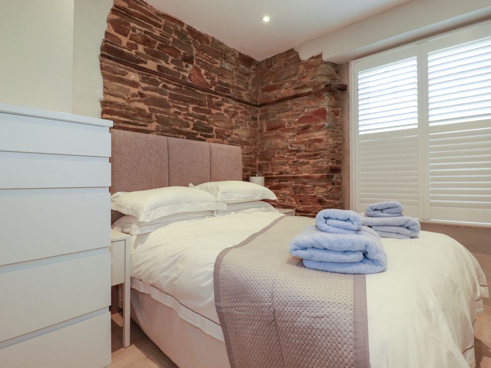 A bedroom with a bed and drawers at Rock House in Trebarwith Strand near Tintagel