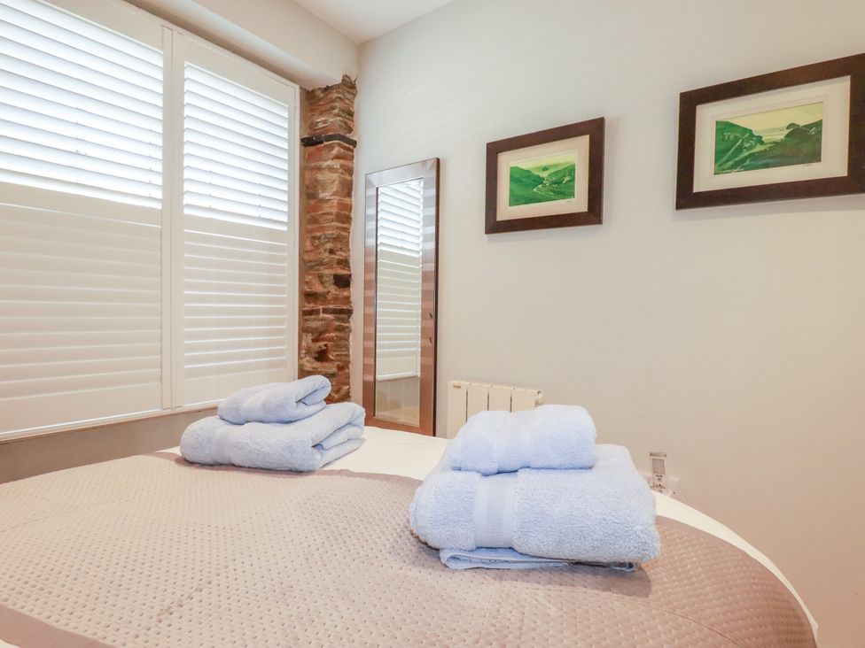 A bathroom with towels and a mirror at Rock House Trebarwith Strand near Tintagel