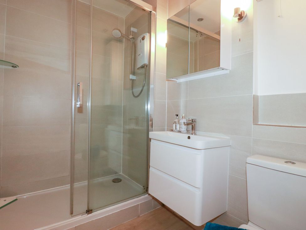 A bathroom with a shower enclosure and sink at Rock House Trebarwith Strand near Tintagel