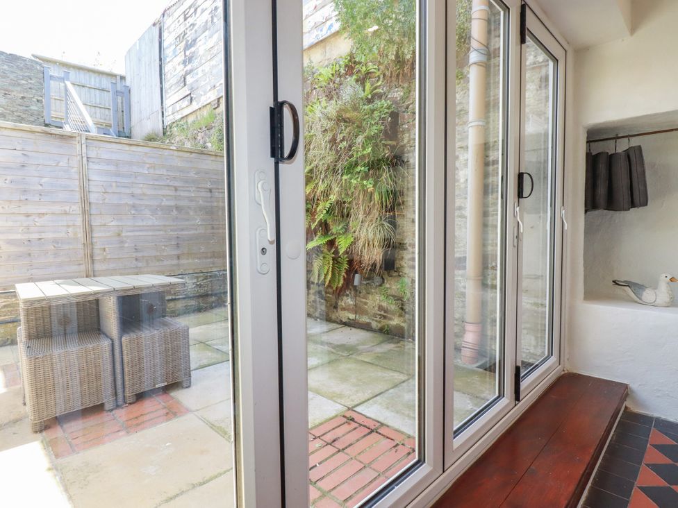 A snug with a glass door opening to a garden at Rock House Trebarwith Strand near Tintagel