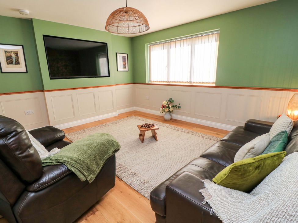 A living room with a television, sofas and a coffee table at The Old Dairy Cotleigh near Honiton
