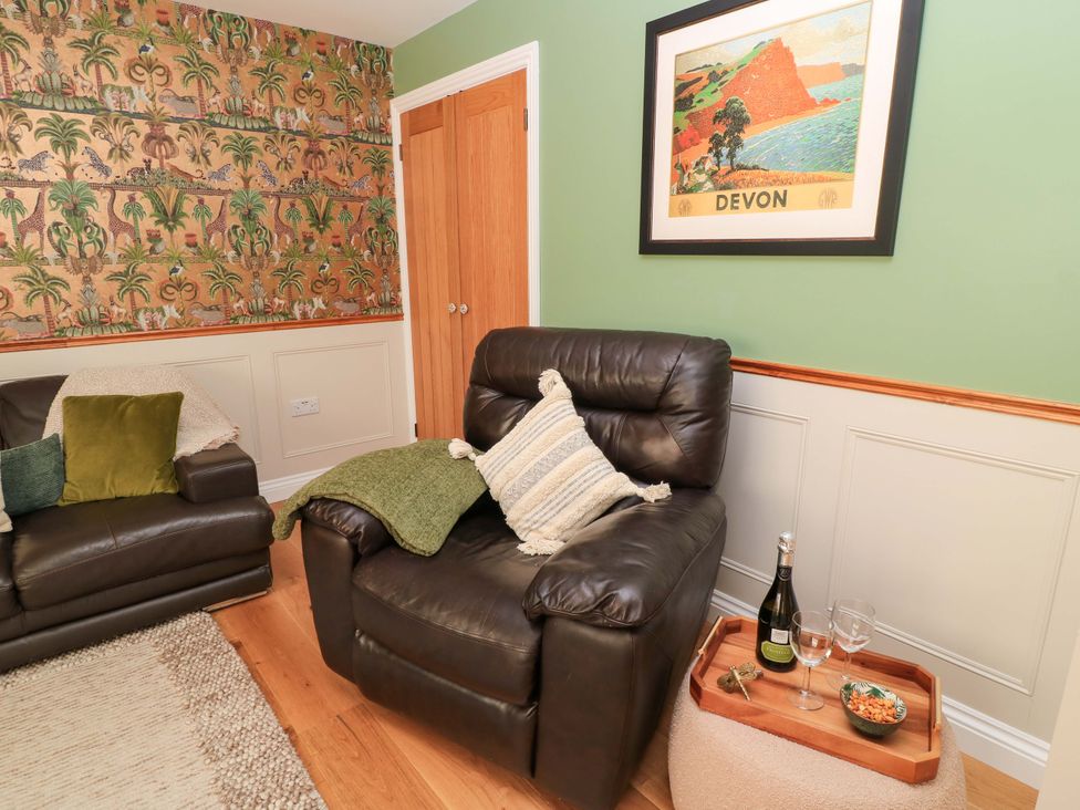A living room with an armchair and a sofa at The Old Dairy in Cotleigh near Honiton