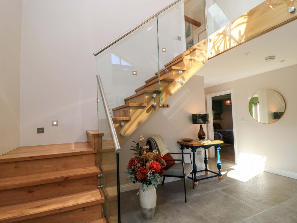 A hallway with stairs and a table at The Old Dairy in Cotleigh near Honiton