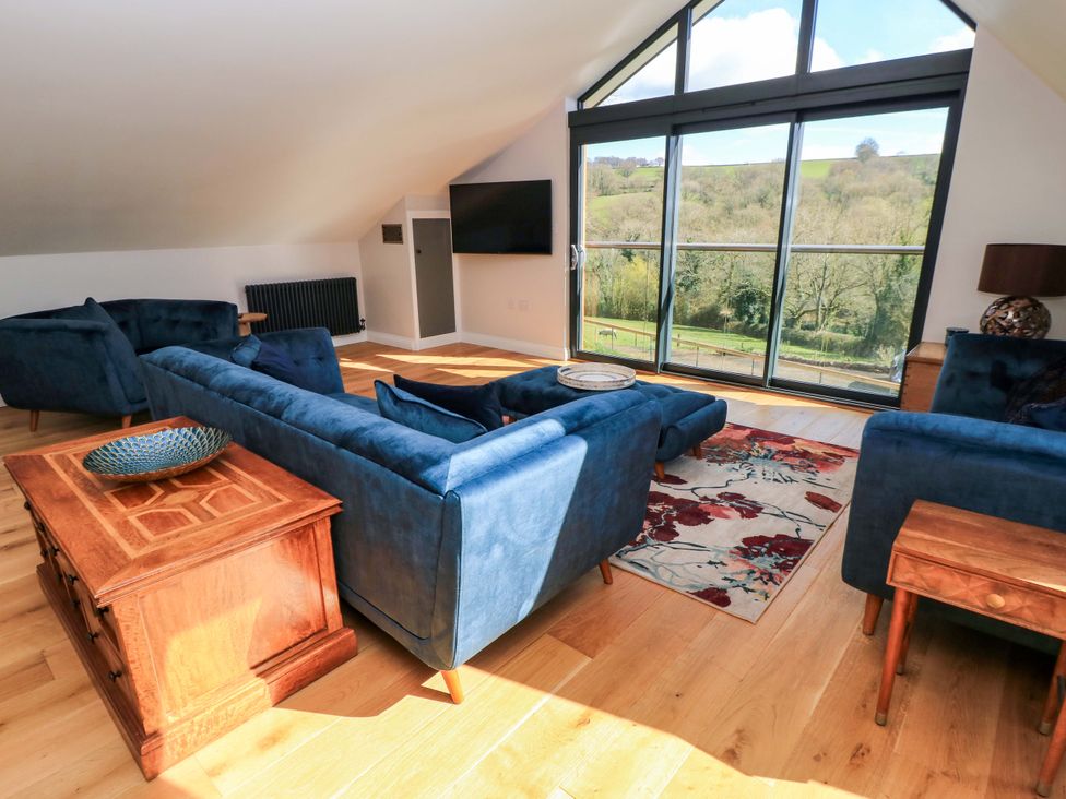 A living room with a sofa and armchairs at The Old Dairy Cotleigh near Honiton