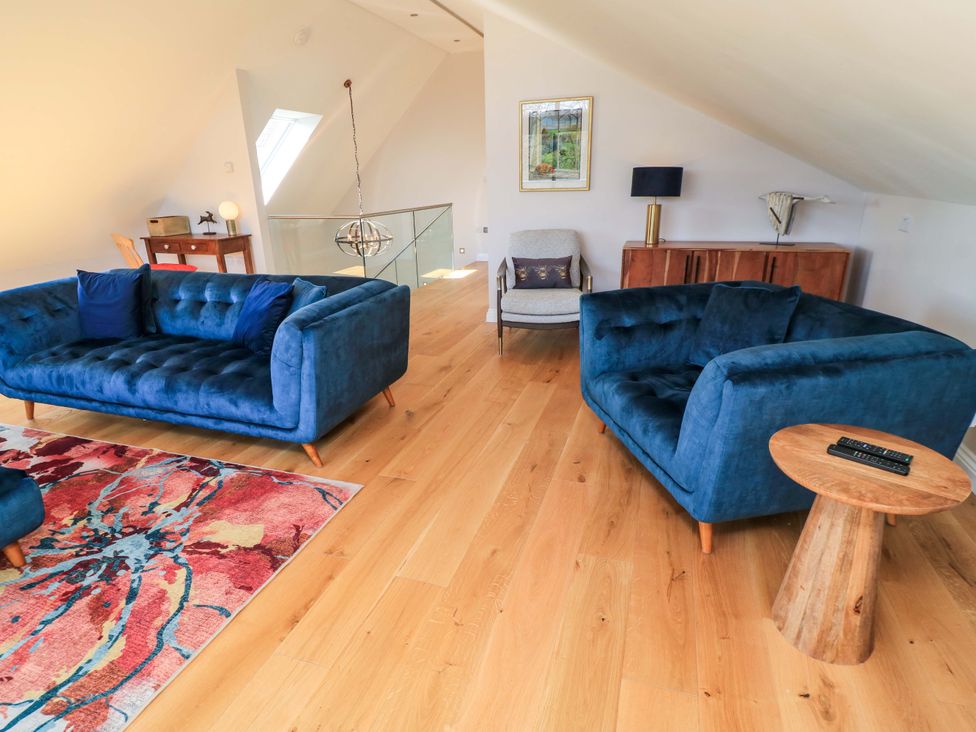 A living room with blue sofas and a coffee table at The Old Dairy near Honiton
