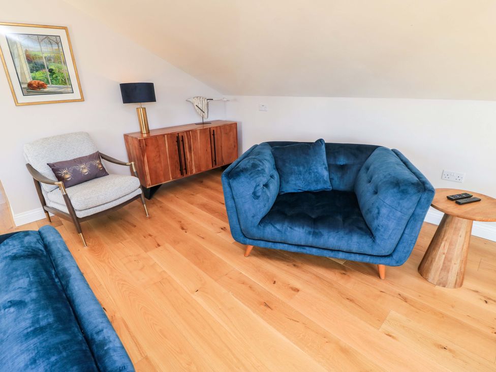 A living room with a sofa and armchair at The Old Dairy Cotleigh near Honiton