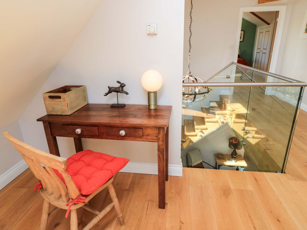A hallway with a desk and chair at The Old Dairy Cotleigh near Honiton